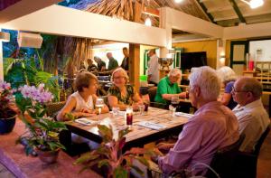 un grupo de personas sentadas en una mesa en un restaurante en Landhuis Daniel - Plantation House, en Tera Kora