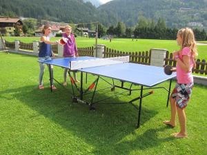 dwie dziewczyny grające w ping ponga na stole do ping ponga w obiekcie Appartement Millennium w mieście Bad Gastein