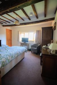 a bedroom with a bed and a desk and a chair at Three Ways Farmhouse B&B in Stratford-upon-Avon