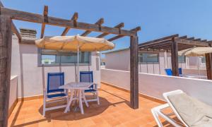 a patio with a table and chairs and an umbrella at Hotel LIVVO Corralejo Beach in Corralejo