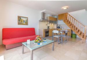 a living room with a red couch and a table at Hotel LIVVO Corralejo Beach in Corralejo