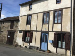 Cette ancienne maison en pierre est dotée d'une porte et de fenêtres bleues. dans l'établissement Gite a la campagne, à Sardent