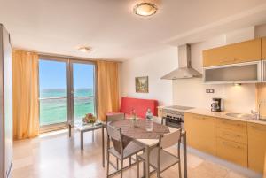 uma cozinha com uma mesa com cadeiras e vista para o oceano em Hotel LIVVO Corralejo Beach em Corralejo