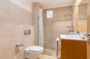 a bathroom with a toilet and a sink and a shower at Hotel LIVVO Corralejo Beach in Corralejo