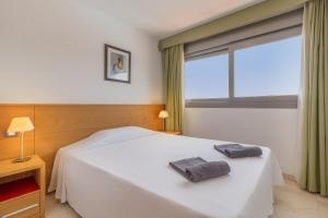 a bedroom with a white bed and a large window at Hotel LIVVO Corralejo Beach in Corralejo