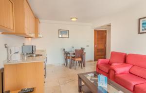 a living room with a red couch and a table at Hotel LIVVO Corralejo Beach in Corralejo