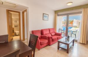 a living room with a red couch and a table at Hotel LIVVO Corralejo Beach in Corralejo