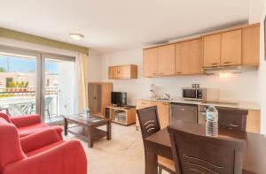 a kitchen and living room with a table and chairs at Hotel LIVVO Corralejo Beach in Corralejo