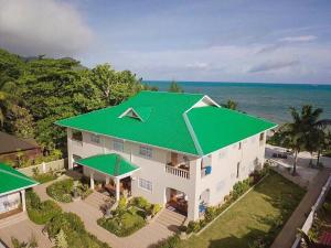 einen Blick über ein Haus mit grünem Dach in der Unterkunft Seashell Beach Villa in Grand'Anse Praslin