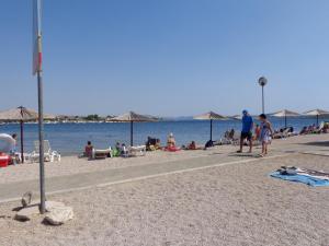 a group of people on a beach with umbrellas at I & S Apartments in Vodice