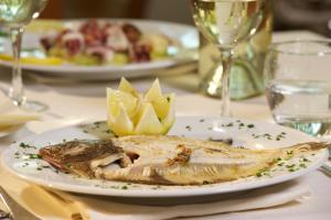 a plate of fish on a table with other plates of food at Hotel Portonuovo in Vieste