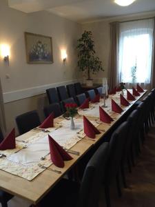 a long table with red napkins and chairs in a room at Zum Grünen Jäger in Barsinghausen