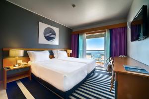 セジンブラにあるSANA セジンブラ オテルの大型ベッドとテレビが備わるホテルルームです。
