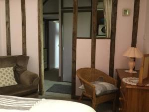 ein Schlafzimmer mit einem Bett, einem Stuhl und einem Spiegel in der Unterkunft Moat Cottage Barns in Corby + 4 Fotos