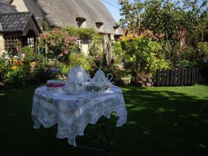 a table with a tea set on it in a yard at Moat Cottage Barns in Corby