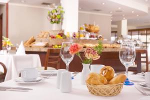 a table with a basket of bread and wine glasses at Hotel Quito by Sercotel in Quito