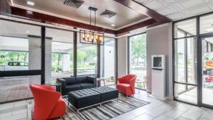 een woonkamer met een zwarte bank en rode stoelen bij Rest and Relax Inn in Pensacola
