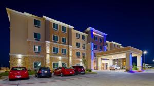 een hotel met auto's geparkeerd op een parkeerplaats bij Best Western Plus Buda Austin Inn & Suites in Buda