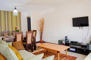 ein Wohnzimmer mit einem Tisch und einem Esszimmer in der Unterkunft Outlink Skyline Minutes to JKIA airport in Nairobi