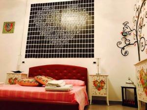 ナルドにあるA Casa di Giorgia "Beautiful House" a Nardò nel Salentoの赤いベッドと白と黒の壁が備わるベッドルーム1室が備わります。