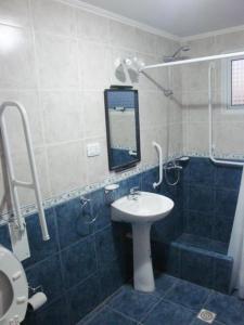 y baño con lavabo y ducha. en Complejo Cabañas Cerro Redondo en Tandil