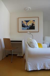 a bedroom with a bed and a desk and a chair at Appartement Les Iris in Bevaix