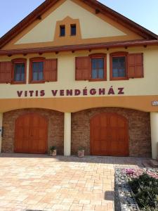 Becsehely的住宿－Vitis Vendégház，一座有红色车库门的建筑,字眼 ⁇ 动