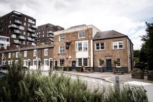 a large brick building in a city with tall buildings at The Pilot Inn in London