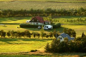 a house and a truck parked in a field at Artun Guesthouse in Artun
