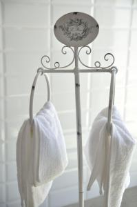 two white towels hanging on a metal towel rack at La Casa De Maria in Algarinejo