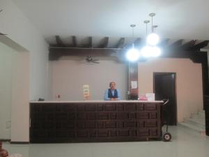 a woman sitting at a counter in a room at Hotel Colon Express in Guadalajara