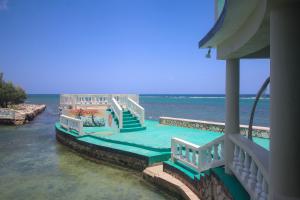 a house with stairs in the water next to the ocean at Sahara Hostel in Montego Bay