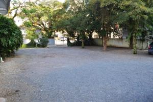 a gravel driveway with trees and a building at Hotel Steinhausen in Blumenau