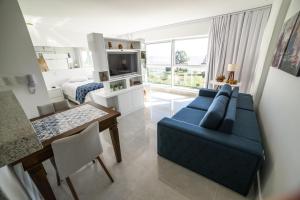sala de estar con sofá azul y mesa en Loft Barra, en Porto Alegre