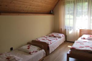 a room with two beds and a window at Mylak BIANCA in Korbielów