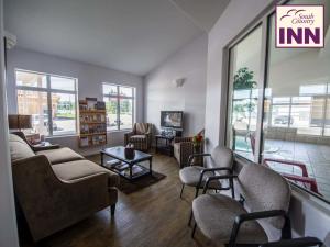 a waiting room with couches and chairs in a building at South Country Inn in Cardston