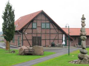 ein großes Backsteingebäude mit Felsen davor in der Unterkunft Landhaus Bondzio in Langen Brütz