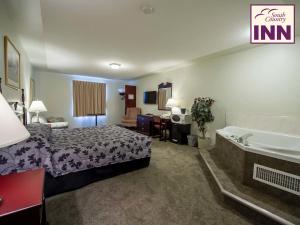 a hotel room with a bed and a bath tub at South Country Inn in Cardston +9 photos