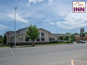 un bâtiment sur le côté d'une route avec un panneau dans l'établissement South Country Inn, à Cardston