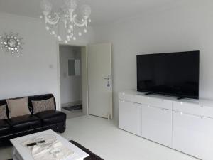 a living room with a black couch and a flat screen tv at Room Agency Zentrum in Hannover