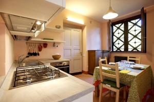 a kitchen with a stove and a table with a dining room at Villa Scagliola in Verbania