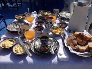 a table topped with plates of food and drinks at La Fontaine Bleue in Essaouira