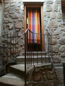 uma escada que leva a uma porta com uma janela colorida em Casamatta a Blera em Blera