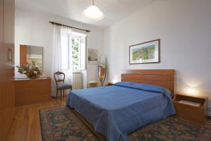 a bedroom with a blue bed and a chair and a window at Piazzale Italia in Oggebbio