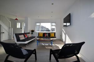 a living room with two chairs and a couch at South Coast Haven Apartments in Peacehaven