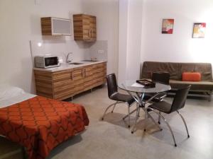 a bedroom with a bed and a table and a kitchen at Llave de Granada in Alcalá la Real