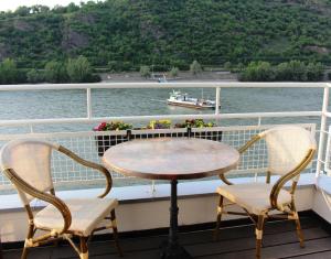 einen Tisch und zwei Stühle auf einem Kreuzfahrtschiff in der Unterkunft Rheinhotel Lilie in Boppard