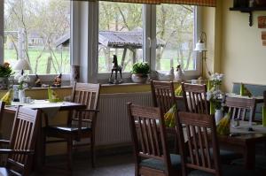 uma sala de jantar com mesas, cadeiras e janelas em Landhaus Bondzio em Langen Brütz