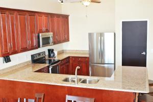 a kitchen with wooden cabinets and a stainless steel refrigerator at Key West Resort - Lake Dora in Tavares