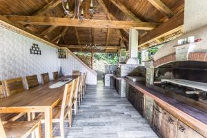 uma cozinha exterior com uma longa mesa e cadeiras de madeira em Apartments Planina pod Sumikom em Planina pod Sumnikom